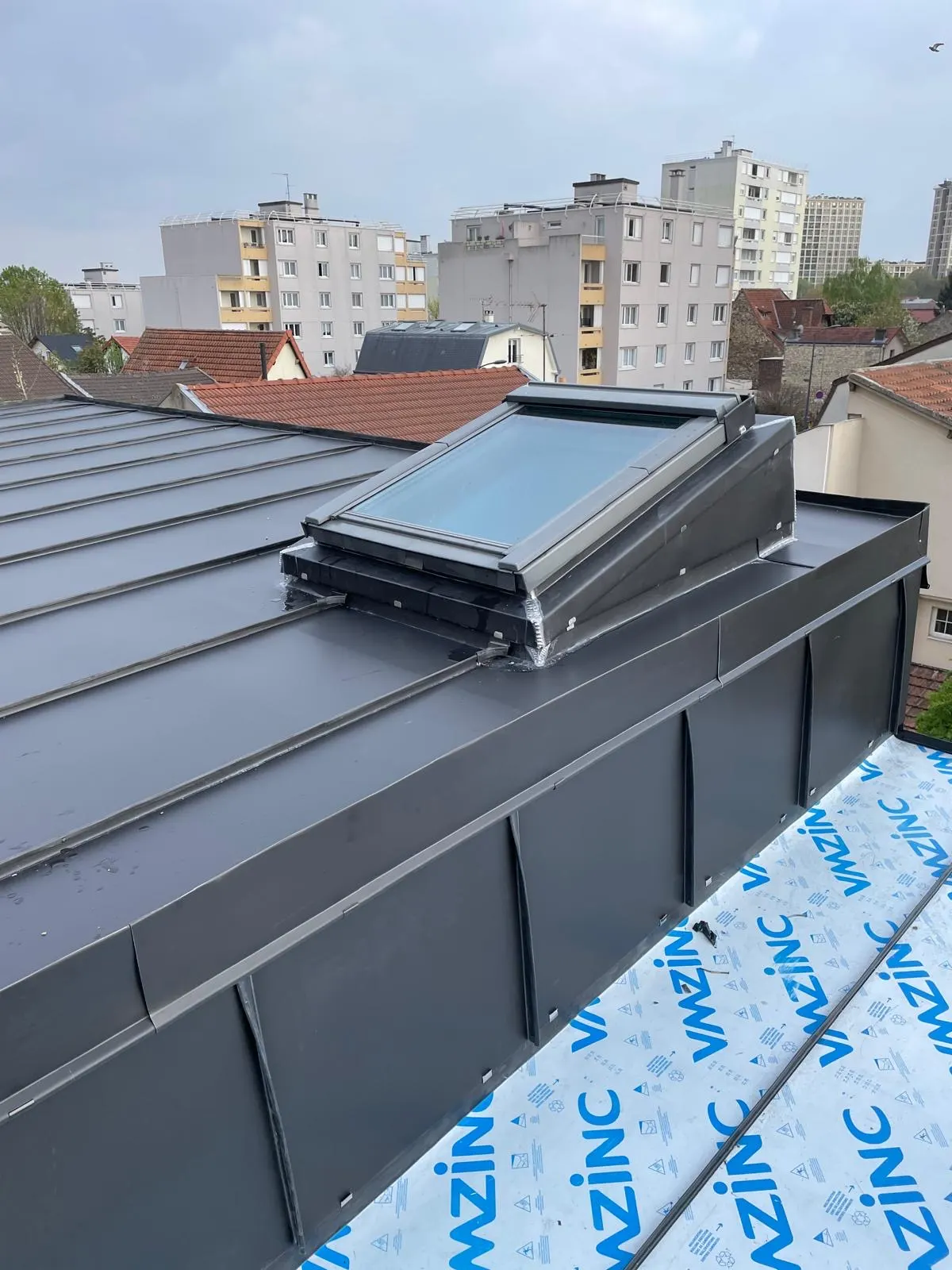 Toiture zinc avec fenêtre de toit et relevé d'étanchéité, chantier de notre équipe en Île-de-France