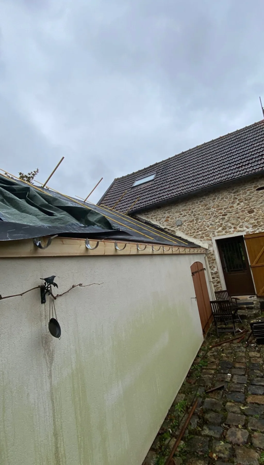 Toiture d’annexe bâchée avec liteaunage et crochets de gouttière pendant les travaux