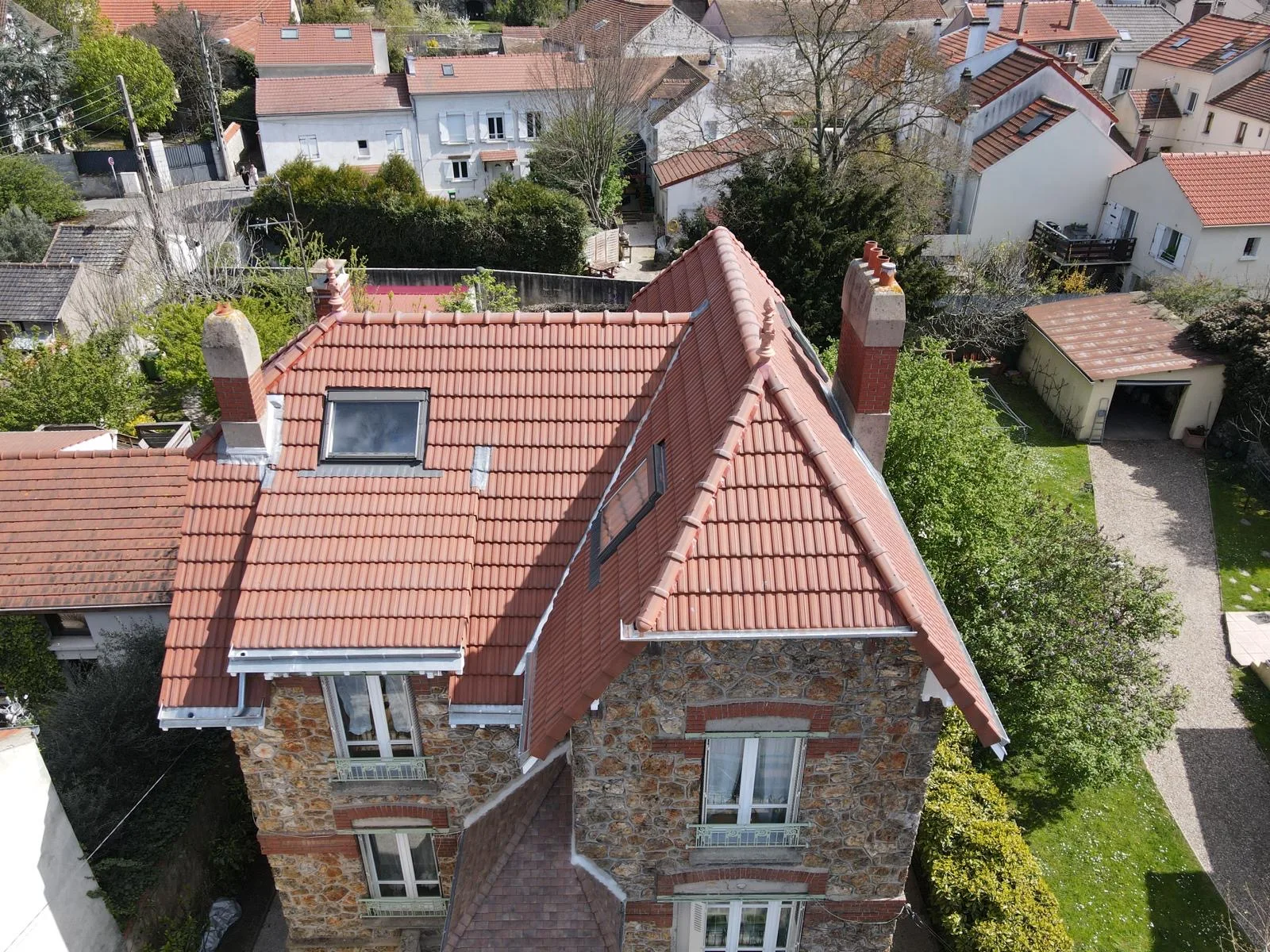 Vue aérienne d'une maison en meulière avec toiture en tuiles neuves et zinguerie refaite