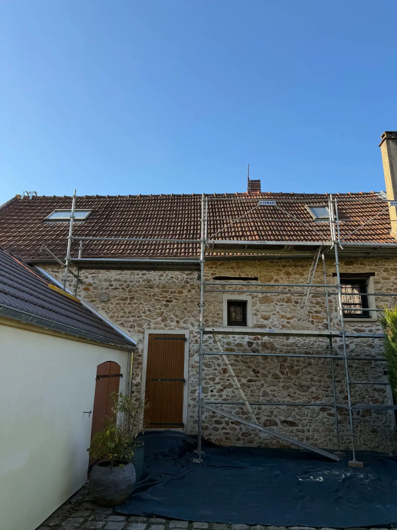 Maison en pierre avec ancienne toiture en tuiles avant réfection