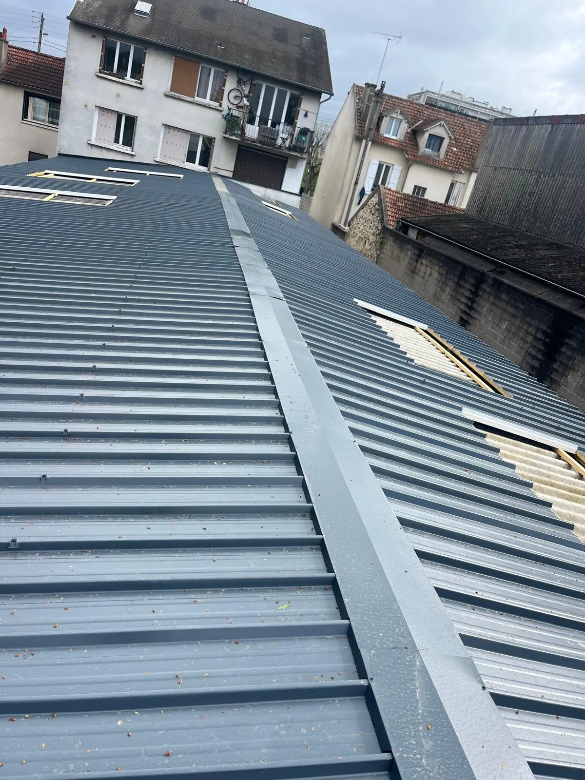Couverture en bac acier posée sur un bâtiment urbain, chantier de notre équipe en Île-de-France