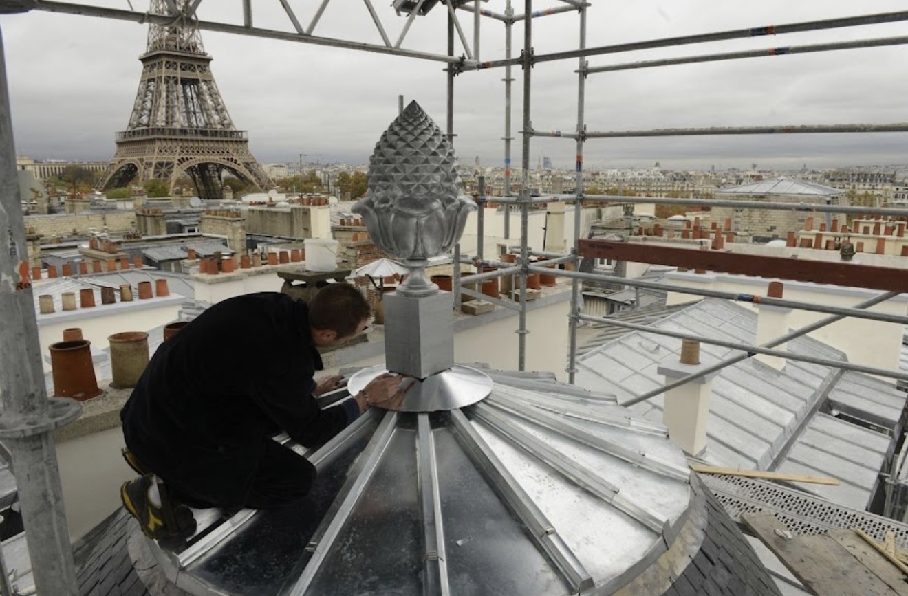 Artisan couvreur Bernard sur un toit parisien face à la Tour Eiffel